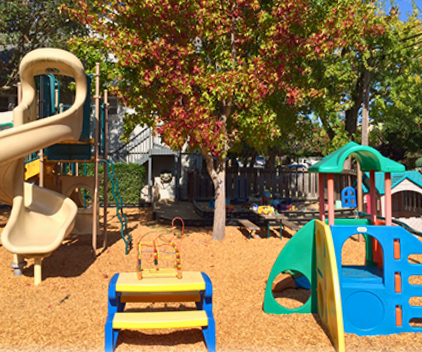 Colorful preschool playground at Stepping Stone Preschool in Burlingame, featuring slides, climbing structures, and safe outdoor play areas for young children.